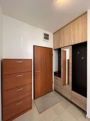 a kitchen with wooden cabinets and a large door at Aurora 3 Apartment in Budva