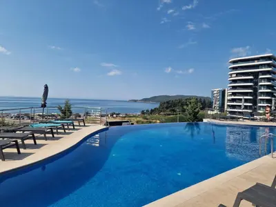 a large swimming pool with a view of a building at Skyline lux apartman Becici sa pogledom na more in Budva