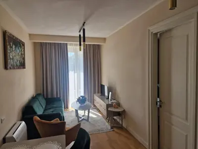a living room with a couch and a tv at Skyline lux apartman Becici sa pogledom na more in Budva