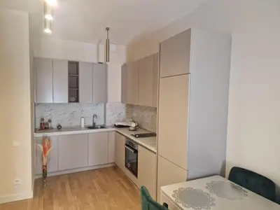 a kitchen with white cabinets and a table at Skyline lux apartman Becici sa pogledom na more in Budva