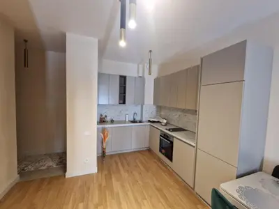 a kitchen with white cabinets and a wooden floor at Skyline lux apartman Becici sa pogledom na more in Budva