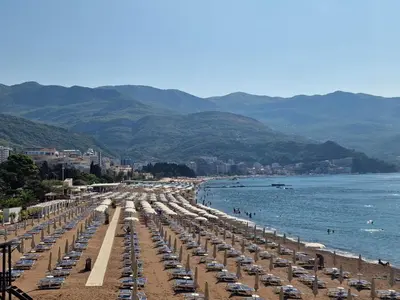 a beach with a bunch of umbrellas and chairs at Skyline lux apartman Becici sa pogledom na more in Budva