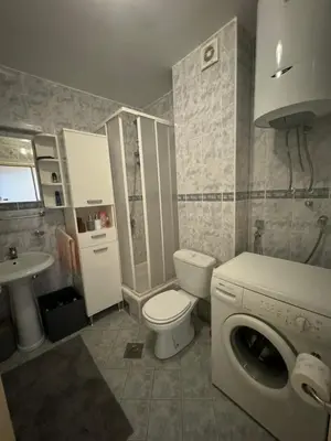 a bathroom with a toilet a sink and a washing machine at Apartman Luka5 in Petrovac na Moru