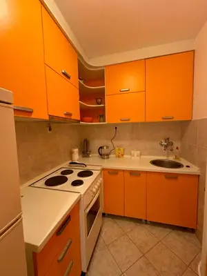 a kitchen with orange cabinets and a stove top oven at Apartman Luka5 in Petrovac na Moru