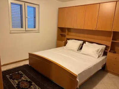 a bedroom with a large bed and a window at Apartman Luka5 in Petrovac na Moru