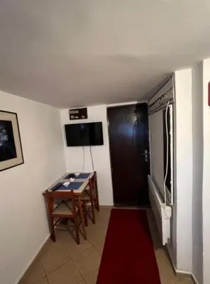 a room with a table and a television in a room at Apartman centar in Podgorica