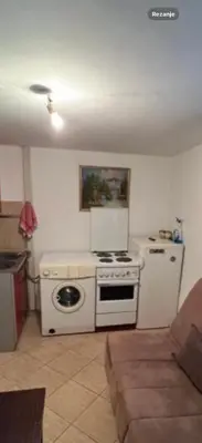 a kitchen with a white stove and a refrigerator at Apartman centar in Podgorica