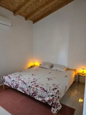 a white bedroom with a bed with flowers on it at Apartment on Long Beach Velika plaza near Ada Bojana in Ulcinj