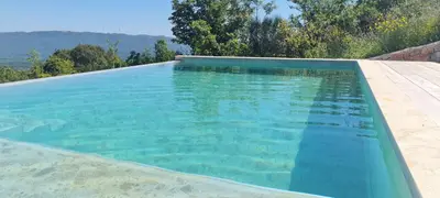 a swimming pool with turquoise blue water at Sunrise Nest - Tinyhouse in Bar