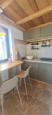 a kitchen with a table and a chair and a sink at Sunrise Nest - Tinyhouse in Bar