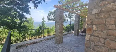 a stone house with a balcony with a view at Sunrise Nest - Tinyhouse in Bar