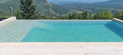 a swimming pool with chairs and mountains in the background at Sunrise Nest - Tinyhouse in Bar