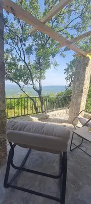 a bench on a patio with a view of the ocean at Sunrise Nest - Tinyhouse in Bar