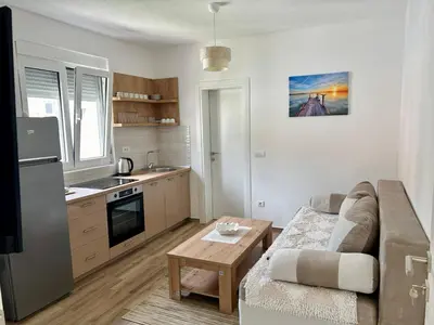 a living room with a couch and a kitchen at Apartman Živaljević 1 Tivat in Tivat
