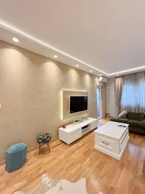 a living room with a flat screen tv on a wall at Modern 1-bedroom apartment M25 in Podgorica