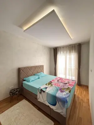 a bedroom with a bed with blue sheets and a window at Modern 1-bedroom apartment M25 in Podgorica
