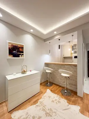 a kitchen with a counter and two stools at Modern 1-bedroom apartment M25 in Podgorica