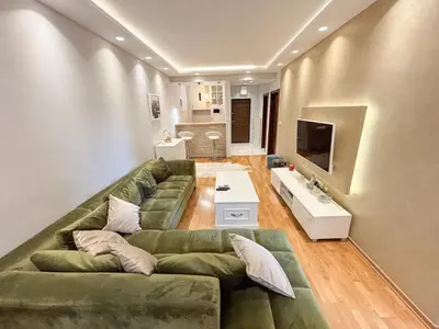 a living room with a green couch and a television at Modern 1-bedroom apartment M25 in Podgorica