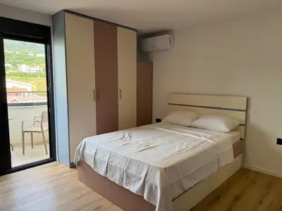 a bedroom with a bed and a large window at Apartment Buena vista in Dobra Voda