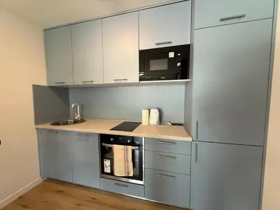 a kitchen with white cabinets and a microwave at Apartment Buena vista in Dobra Voda