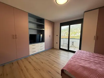 a bedroom with a bed and a tv and a window at Apartment Buena vista in Dobra Voda