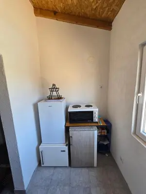 a small kitchen with a refrigerator and a microwave at Penthouse apartman Ogist Velika plaza Long beach near Ada Bojana in Donji Štoj