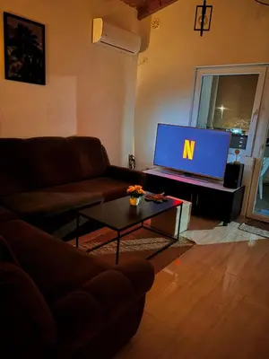 a living room with a couch and a tv at Penthouse apartman Ogist Velika plaza Long beach near Ada Bojana in Donji Štoj