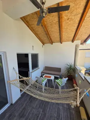 a hammock in a living room with a ceiling fan at Penthouse apartman Ogist Velika plaza Long beach near Ada Bojana in Donji Štoj