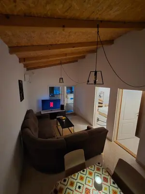a living room with a couch and a tv at Penthouse apartman Ogist Velika plaza Long beach near Ada Bojana in Donji Štoj