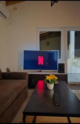 a living room with a tv with the n on it at Penthouse apartman Ogist Velika plaza Long beach near Ada Bojana in Donji Štoj