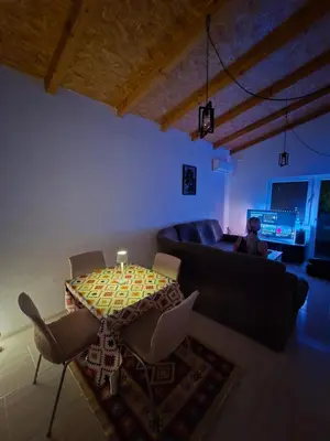 a living room with a table and a couch at Penthouse apartman Ogist Velika plaza Long beach near Ada Bojana in Donji Štoj