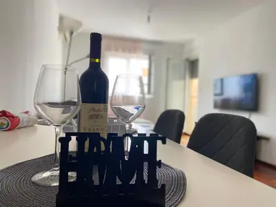 a bottle of wine and two glasses on a table at One bedroom apartment Podgorica in Podgorica