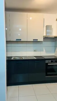 a kitchen with black and white cabinets and a sink at One bedroom apartment Podgorica in Podgorica