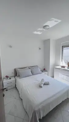 a white bedroom with a large bed and a window at Villa Giovanna in Donji Štoj