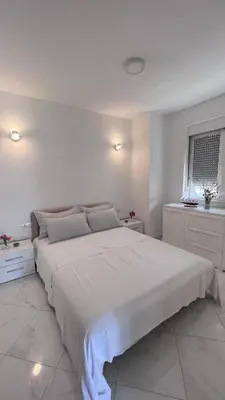 a white bedroom with a large bed and a window at Villa Giovanna in Donji Štoj