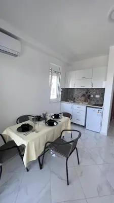 a white kitchen with a table and chairs in a room at Villa Giovanna in Donji Štoj