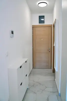 a hallway with a door and a room with white walls at Studio GRIGÓ in Budva