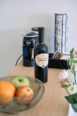 a bottle of wine and a bowl of apples on a table at Studio GRIGÓ in Budva