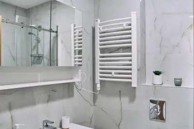 a white bathroom with a sink and a mirror at Studio GRIGÓ in Budva
