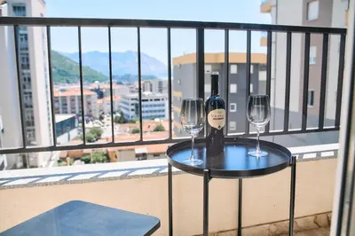 a table with two glasses of wine on a balcony at Studio GRIGÓ in Budva