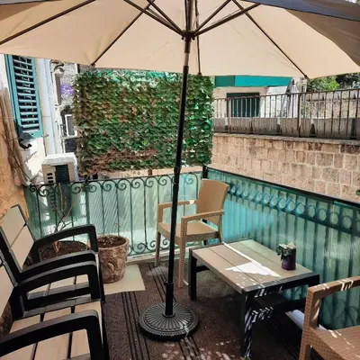 a patio with a table and an umbrella at Apartman HOME Kotor in Kotor