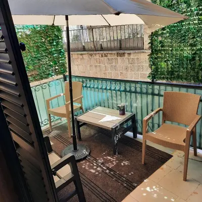 a table and two chairs and an umbrella on a patio at Apartman HOME Kotor in Kotor