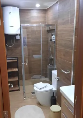 a bathroom with a toilet and a glass shower at Apartman HOME Kotor in Kotor