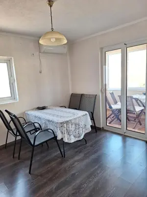a dining room with a table and chairs and a balcony at a cozy corner in Bar