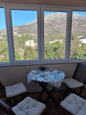 a table and two chairs in a room with windows at a cozy corner in Bar