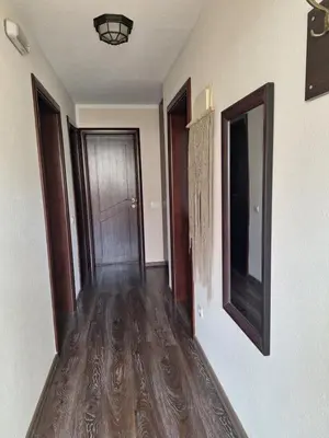 an empty hallway with wood floors and a door at a cozy corner in Bar