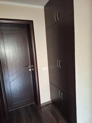 a room with brown cabinets and a wooden door at a cozy corner in Bar