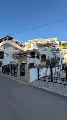 a white house with a fence in front of it at Zaytoon Residence in Ulcinj