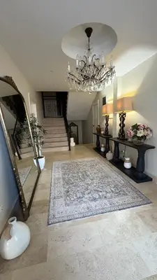 a living room with a chandelier and a carpet at Zaytoon Residence in Ulcinj
