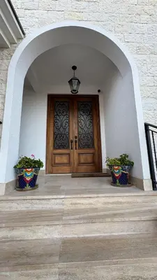 a front door of a building with two potted plants at Zaytoon Residence in Ulcinj